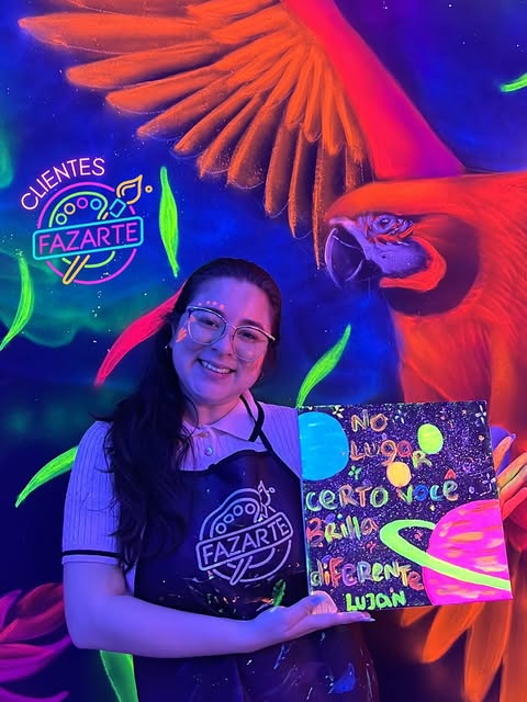 Visitante sorrindo com tela pintada em cores fluorescentes